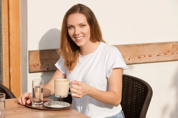 Красива молода біла жінка п'є каву рано вранці — стокове фото