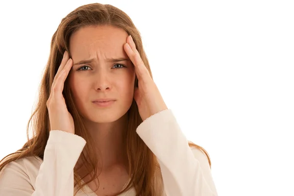 Beautiful young brunette woman holds her head as she has headach — Stock Photo, Image