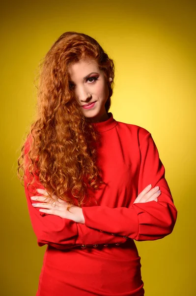 Beauty portrait of a preety redhead in red elegant dress over gr — Stock Photo, Image