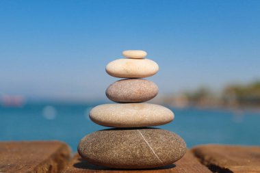 Zen konsepti. Kumsalda taş yığını. Arka plan bulanık. Uyum, istikrar, yaşam dengesi ve meditasyon kavramı..