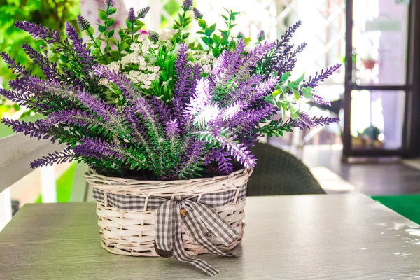Decorative lavender flowers in a basket on a summer terrace table in a cafe — Stock Photo, Image