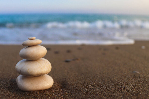 Пирамида камней на берегу моря. Концепция дзен. Понятие гармонии, стабильности, баланса жизни, релаксации и медитации. Размытый фон, пространство для копирования текста, выборочная фокусировка.