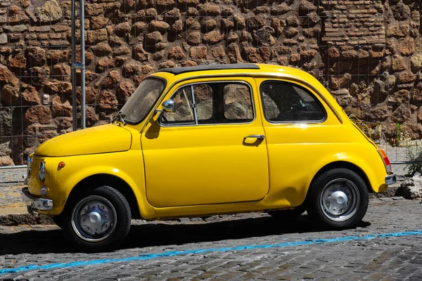 Rome, Italy - June 30, 2019: Cute little yellow retro car Fiat with a small dent parked on street — Stock Photo, Image