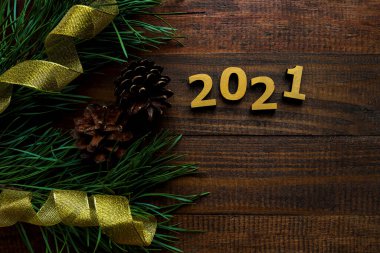 Fotokopi alanı olan yeni yıl festivali arka planı. Çam dalları, kozalaklar ve altın kurdeleli 2021 altın numaralar. Noel ya da yeni yıl kartı. Şenlikli, tatil konsepti. Düz yatış, üst görünüm.