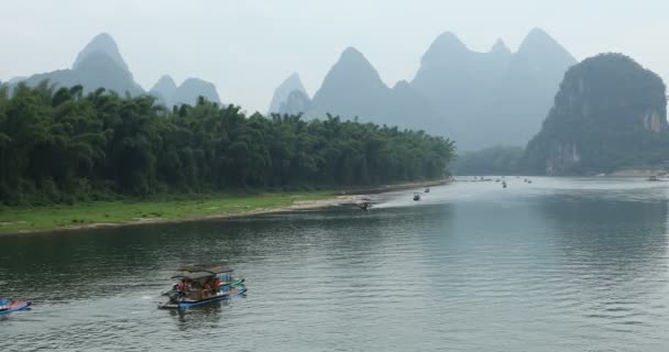 緑の森と陽朔県の桂林 中国でカルストの中で李川に沿って航行ボートの眺め 陽朔はアジアの人気観光地です — ストック動画