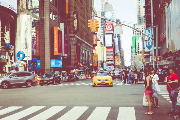 NEW YORK - SEPTEMBER 2, 2018: New York City street road in Manhattan at summer time, many cars, yellow taxis and busy people walk to work.