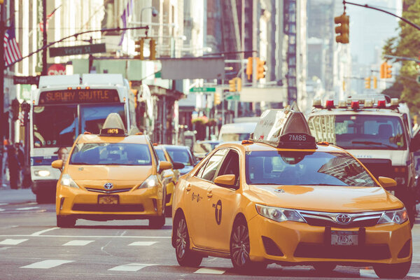 NEW YORK - SEPTEMBER 2, 2018: Yellow cab speeds through Times Square the busy tourist intersection of neon art and commerce and is an iconic street of New York City, USA.