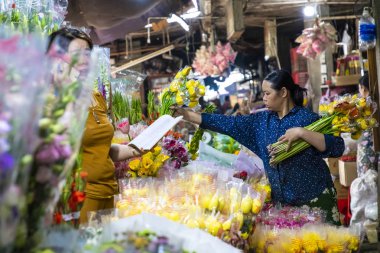 Hue, Vietnam - Kasım 19,2018: Vietnam yerel pazardaki satıcılar. Geleneksel bir pazarın üzerinde taze çiçekler.