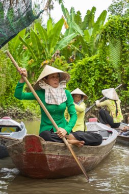 Benim Tho, Vietnam - 24 Kasım 2018: Vietnam kadınlar geleneksel Vietnam şapkalı My Tho şehirde (Güney Vietnam Mekong Deltası bölgesinde Mekong Nehri üzerinde turist ile küçük bir tekne kürek)