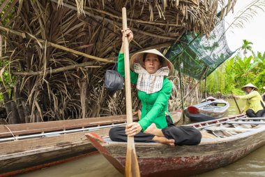 Benim Tho, Vietnam - 24 Kasım 2018: Vietnam kadınlar geleneksel Vietnam şapkalı My Tho şehirde (Güney Vietnam Mekong Deltası bölgesinde Mekong Nehri üzerinde turist ile küçük bir tekne kürek)