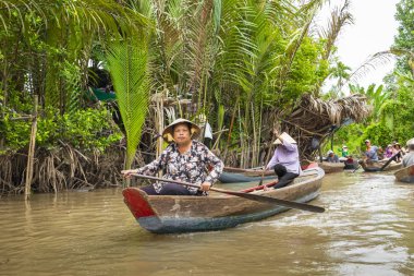 Benim Tho, Vietnam - 24 Kasım 2018: Mekong Nehri Deltası orman cruise ile tanımlanamayan craftman ve balıkçı kürekli tekneler çamurlu lotus alanı Mekong Deltası'nda sel.