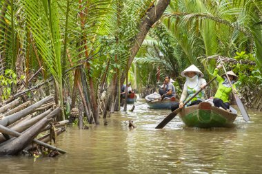 Benim Tho, Vietnam - 24 Kasım 2018: Vietnam kadınlar geleneksel Vietnam şapkalı My Tho şehirde (Güney Vietnam Mekong Deltası bölgesinde Mekong Nehri üzerinde turist ile küçük bir tekne kürek)