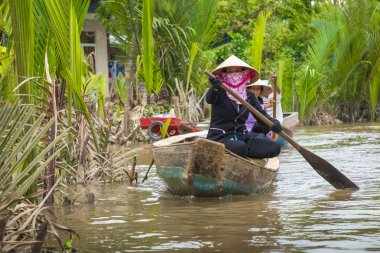 Benim Tho, Vietnam - 24 Kasım 2018: Vietnam kadınlar geleneksel Vietnam şapkalı My Tho şehirde (Güney Vietnam Mekong Deltası bölgesinde Mekong Nehri üzerinde turist ile küçük bir tekne kürek)