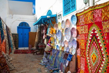 Geleneksel Tunesian halılar mavi tatil beldesi Sidi Bou Said duvarlarda asılı. Tunus, Kuzey Afrika.