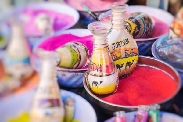 Souvenirs from Jordan - bottles with sand and shapes of desert and camels. Selective Focus.