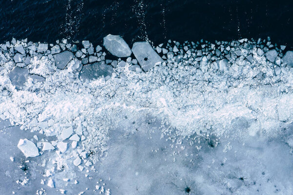 Glacier Lagoon with icebergs from above. Aerial View. Cracked Ice from drone view. Background texture concept.