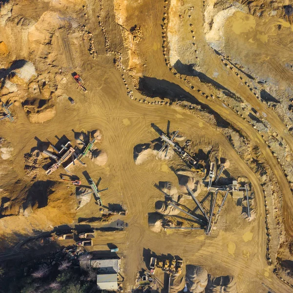 Aerial view of opencast mining quarry with lots of machinery. Industrial place view from above. Photo captured with drone.