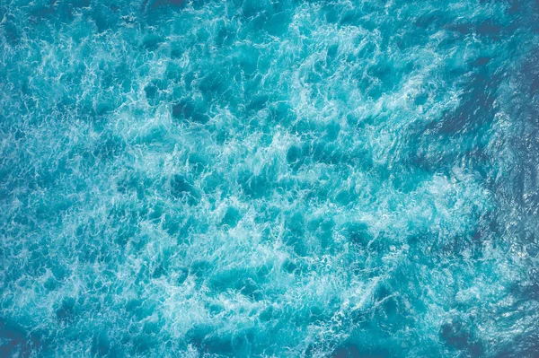 Vista superior de la superficie azul espumosa del mar. Disparo en el mar abierto desde un — Foto de Stock