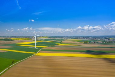 Rüzgar türbininin havadan görünümü. Kolza çiçeği. Yel değirmenleri ve ye
