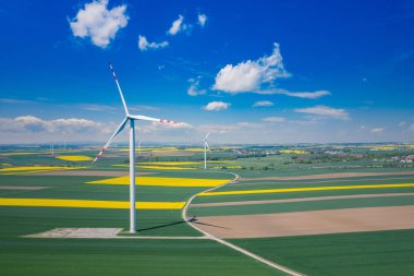 Rüzgar türbininin havadan görünümü. Kolza çiçeği. Yel değirmenleri ve ye