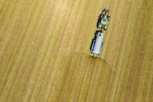 Vue aérienne du labour et de la pulvérisation de tracteurs agricoles sur le terrain. A — Photo