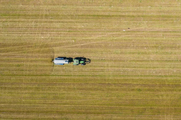 Aerial view of farming tractor plowing and spraying on field.  A — Stock Photo, Image