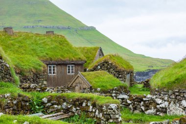 View of fishing village in Koltur island. Faroe Islands. Green r clipart
