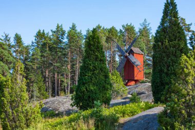 Red wooden windmill in a old vintage rural landscape at Aland is clipart