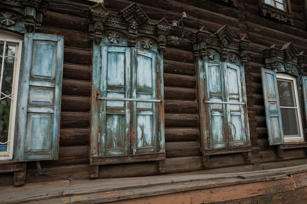 Window with the wooden carved architrave in the old wooden house — Stock Photo, Image