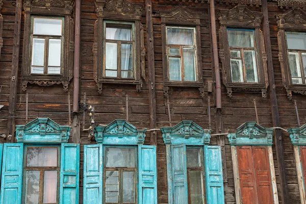 Window with the wooden carved architrave in the old wooden house — Stock Photo, Image