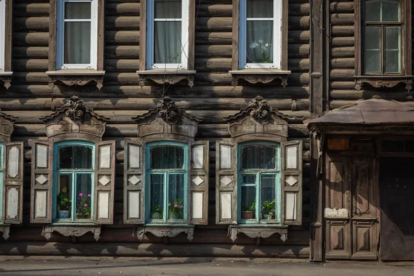 古い木造家屋の木彫りのアーキトレーブを持つ窓 — ストック写真
