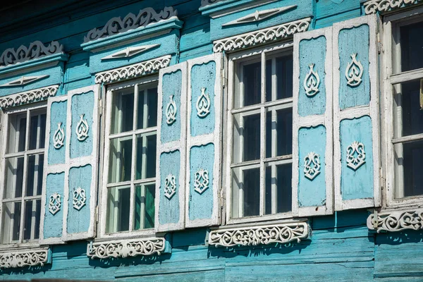 Raam met de houten gebeeldhouwde architraaf in het oude houten huis — Stockfoto