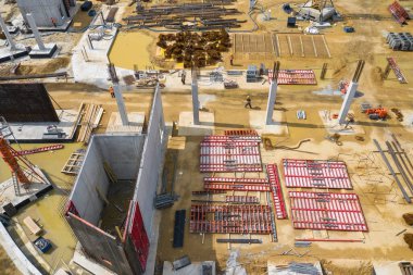 Yukarıdan inşaat alanı. İnşaat malzemelerindeki işyerlerinin havadan görünüşü, ağır makineli işçiler. İnsansız hava aracı tarafından yapılan endüstriyel üst görünüm. 