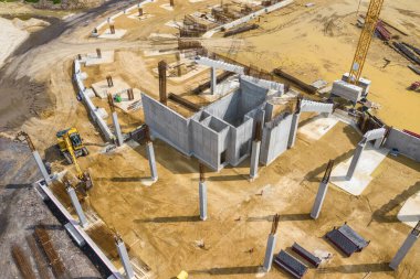 Yukarıdan inşaat alanı. İnşaat malzemelerindeki işyerlerinin havadan görünüşü, ağır makineli işçiler. İnsansız hava aracı tarafından yapılan endüstriyel üst görünüm. 