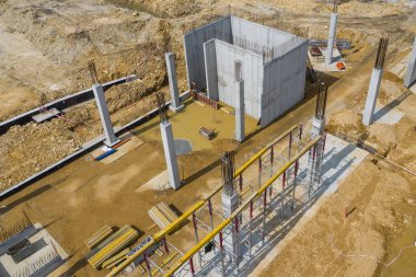 Yukarıdan inşaat alanı. İnşaat malzemelerindeki işyerlerinin havadan görünüşü, ağır makineli işçiler. İnsansız hava aracı tarafından yapılan endüstriyel üst görünüm. 