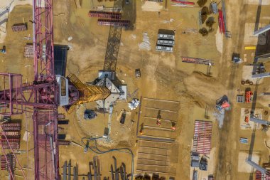 Yukarıdan inşaat alanı. İnşaat malzemelerindeki işyerlerinin havadan görünüşü, ağır makineli işçiler. İnsansız hava aracı tarafından yapılan endüstriyel üst görünüm. 