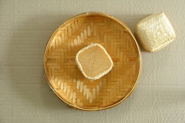 Açık kahverengi karton kutuda izole edilmiş bambu sepetli el..