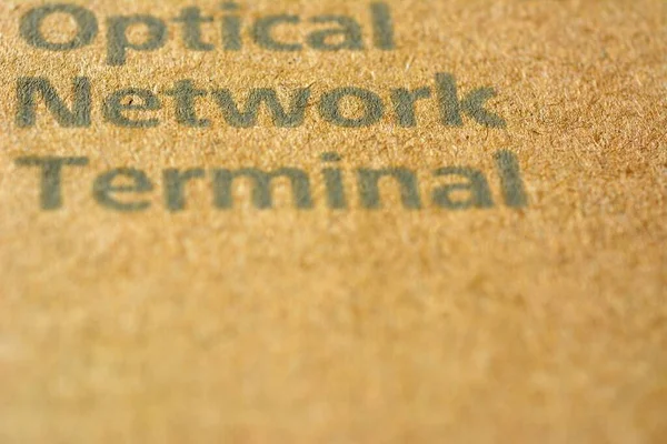 Optical network terminal text on light brown paper blurred background.