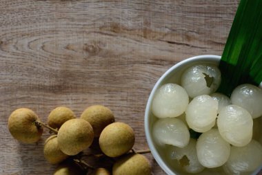 Şuruplu Longan ve ahşap arka planda pandan yaprağı. Geleneksel Thai tatlısı..
