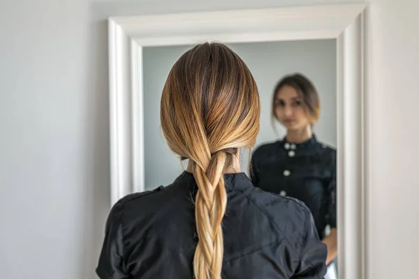 Mulher menina com penteado ombre em trança na frente do espelho — Fotografia de Stock