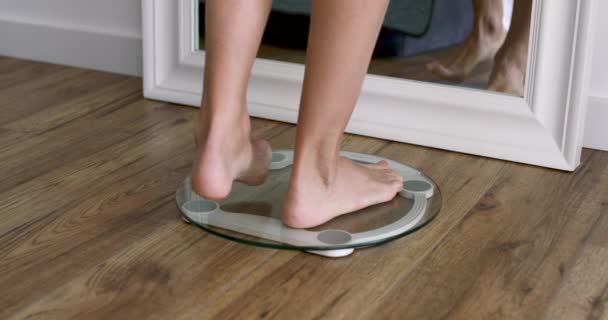 Femme debout sur les écailles pieds nus, gros plan à la maison, mesure le poids — Video