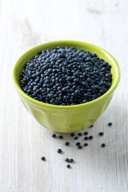 kabın içinde masada siyah mercimek