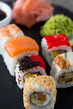 İştah açıcı suşi çeşitler kara tahta üzerinde