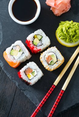 İştah açıcı suşi çeşitler kara tahta üzerinde