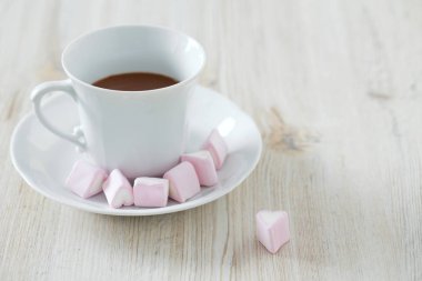 ahşap masa üzerinde sıcak çikolata ve kalp şeklindeki hatmi