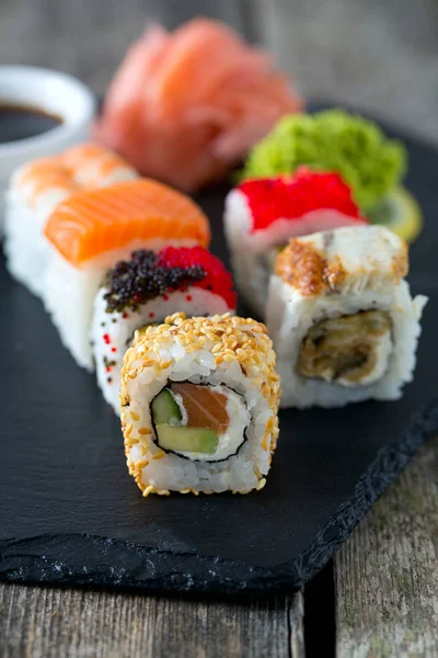 İştah açıcı suşi çeşitler kara tahta üzerinde