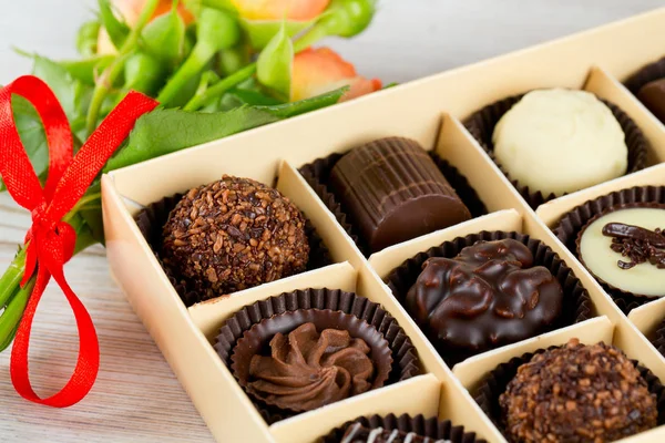 Mooie Zacht Oranje Rozen Zoete Chocolade Snoepjes Vak Houten Oppervlak — Stockfoto