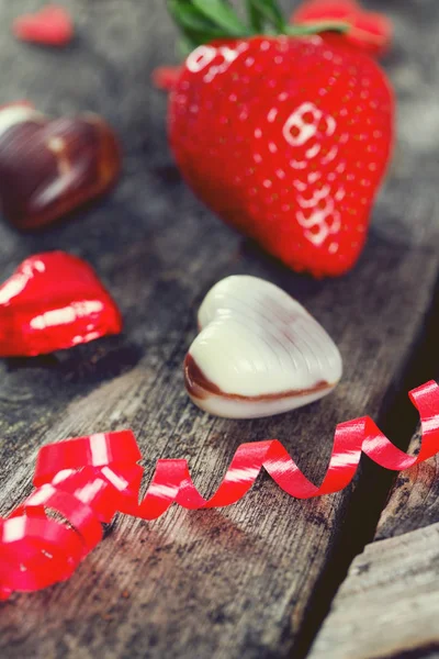 Süßigkeiten Und Herzen Auf Holzgrund — Stockfoto