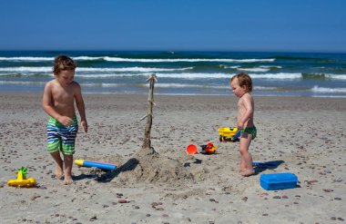 Kumsalda oynarken çocuklar