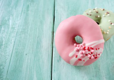 Turkuaz ahşap yüzey üzerinde renkli donut